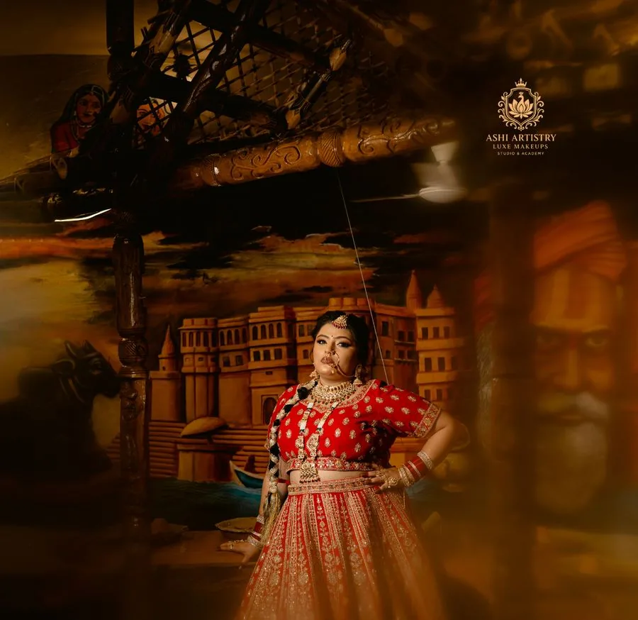 Bridal portrait in a red lehenga at a heritage gateway