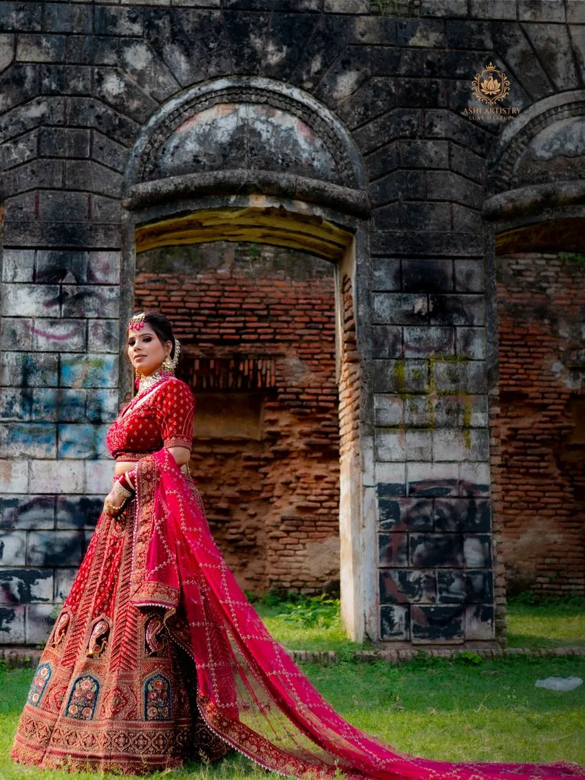 Bridal portrait in a red lehenga at a heritage archway