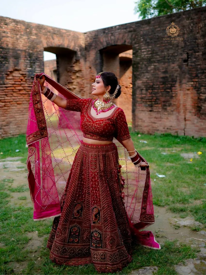 Bride twirling her dupatta at a heritage archway