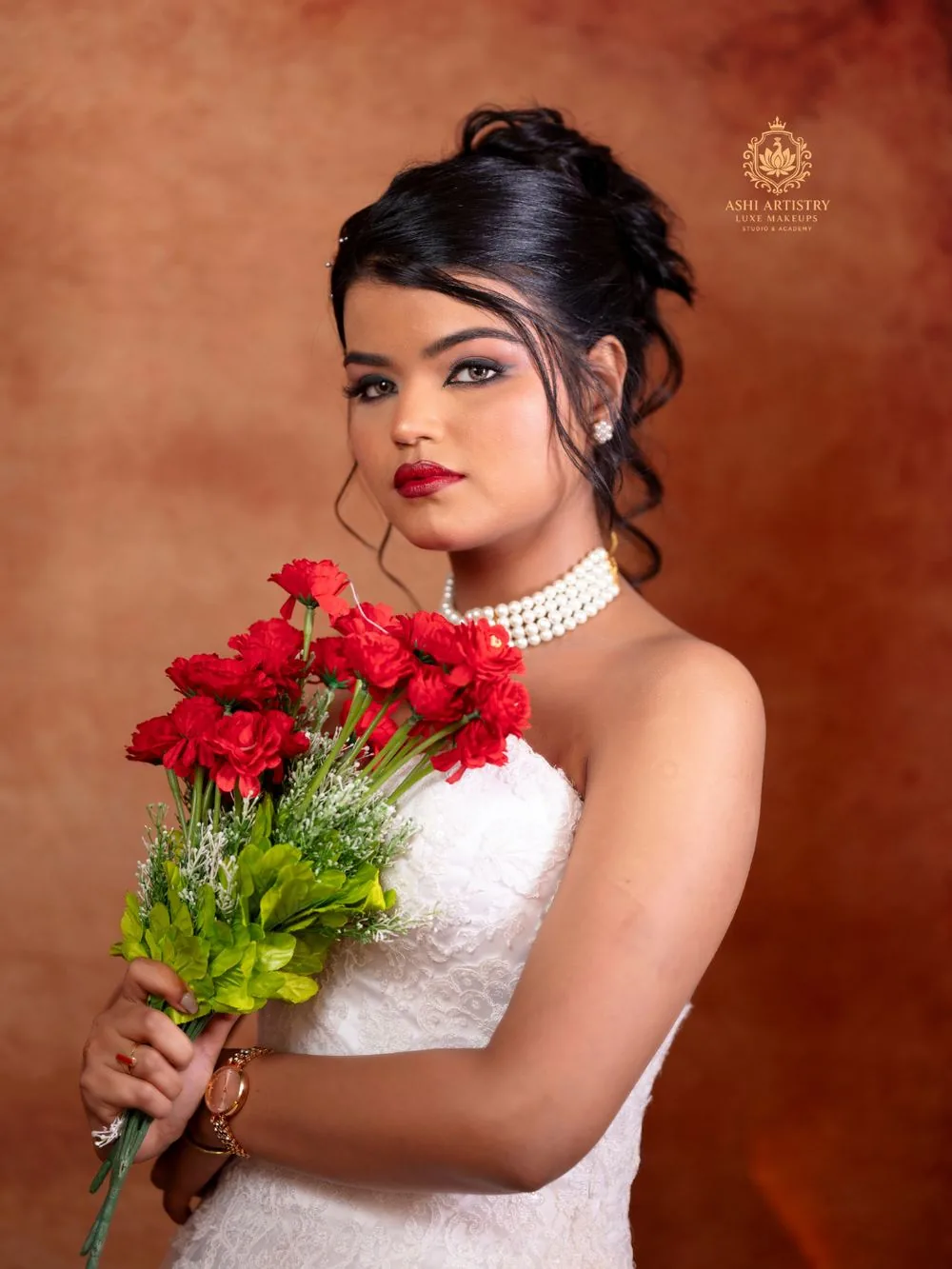 Bride in a white gown holding a red rose bouquet