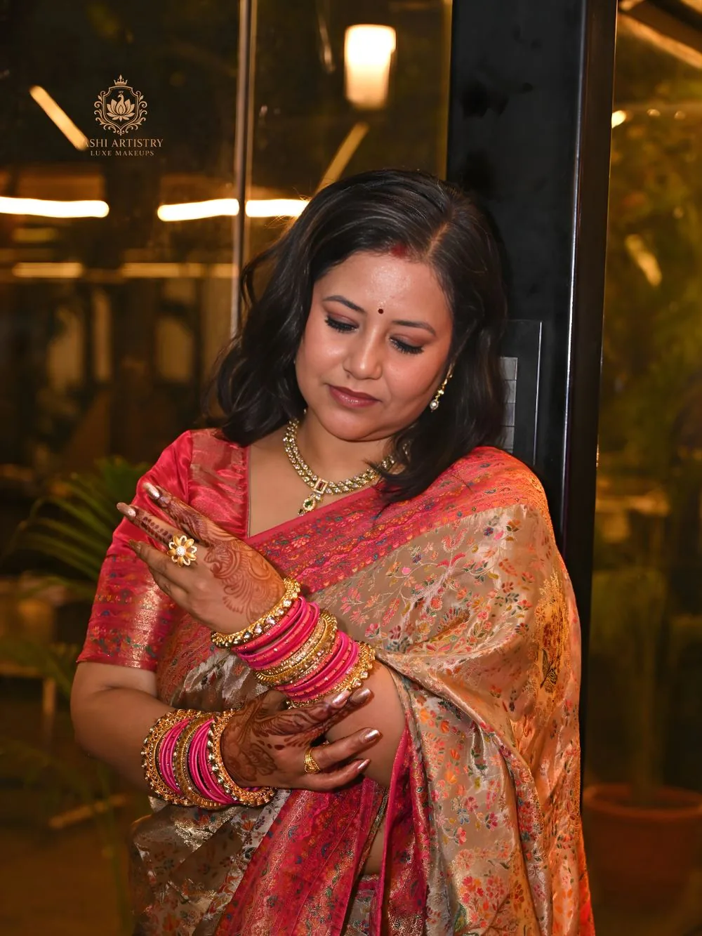 Close-up of hands with bangles and jewellery in a festive saree